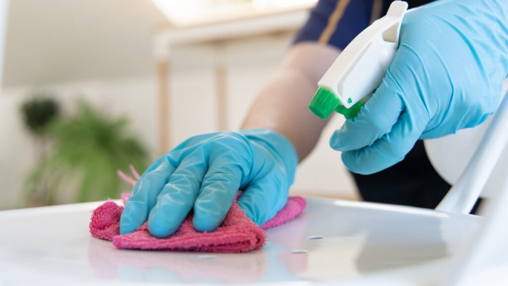 Deep cleaning team carefully wiping a countertop with disinfectant for a spotless result.
